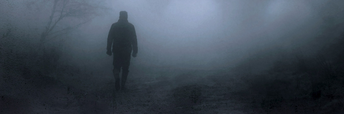 Riconoscere e superare gli stati d'ansia e gli attacchi di panico Uomo di spalle in un bosco avvolto dalla nebbia fitta