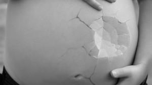 Pancione di una donna incinta: è rotto come un guscio d'uovo