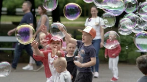 Bambini che al parco giocano con le bolle di sapone. Stare bene insieme non sempre è innato: a volte serve impararlo