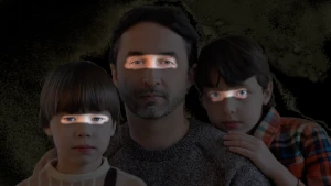Piano americano di papà, figlia e figlio. La foto è tutta oscurata tranne gli occhi. Gli occhi del papà sono fondamentali agli occhi dei figli