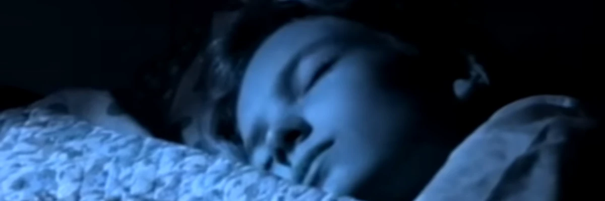 Primo piano di una ragazza che dorme sotto le coperte